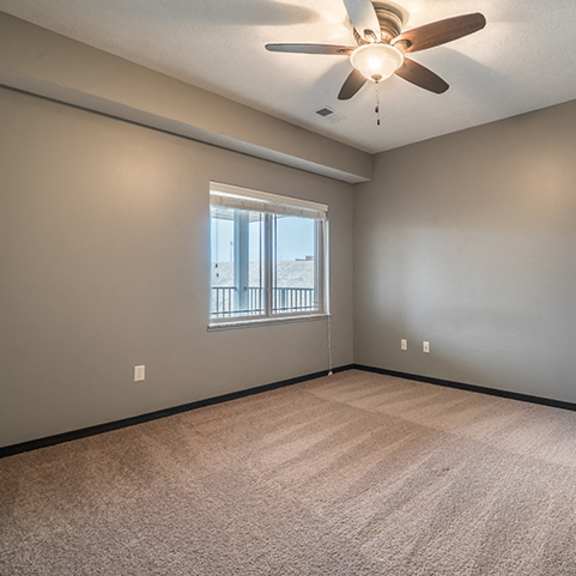 Thumbnail 9 of 11 Bedroom with ceiling fan and abundant natural lighting at the Villas of Omaha at Butler Ridge in Omaha Nebraska