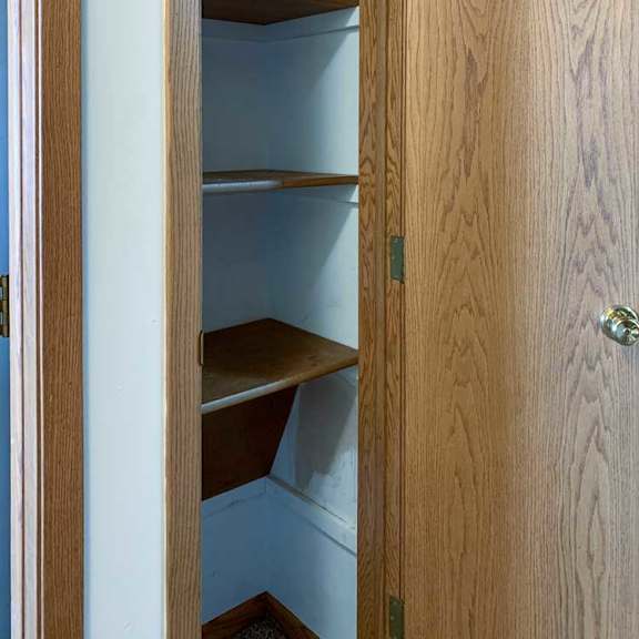 Thumbnail 11 of 30 a linen closet with wooden shelves and a door