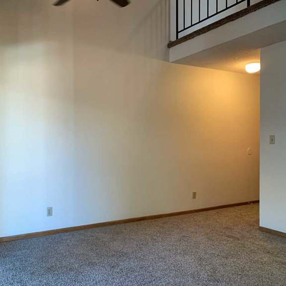 Thumbnail 9 of 30 a living room with a vaulted ceiling, ceiling fan, and a loft area above