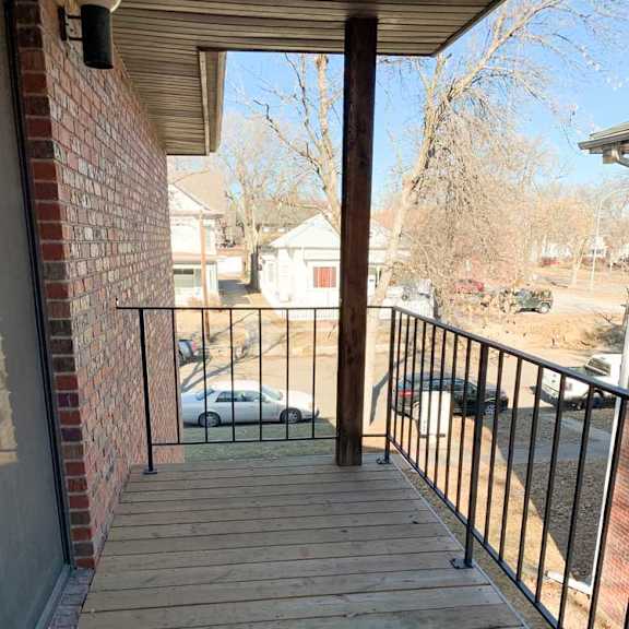 Thumbnail 8 of 30 a wooden deck with a metal railing and a view of a street