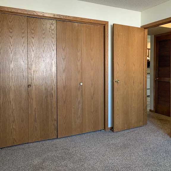 Thumbnail 13 of 30 a bedroom with a closed sliding door closet and a door open to the hallway