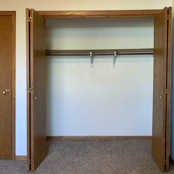 Thumbnail 19 of 30 a bedroom with a sliding door closet with a built-in shelf