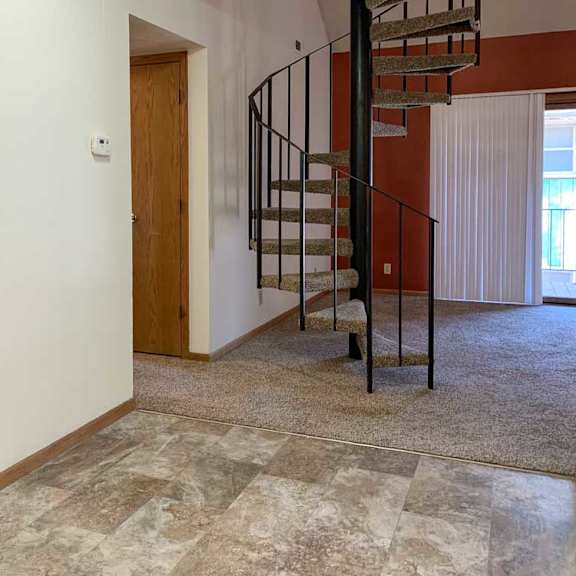 Thumbnail 5 of 30 a kitchen that connects to a living room with a spiral metal staircase
