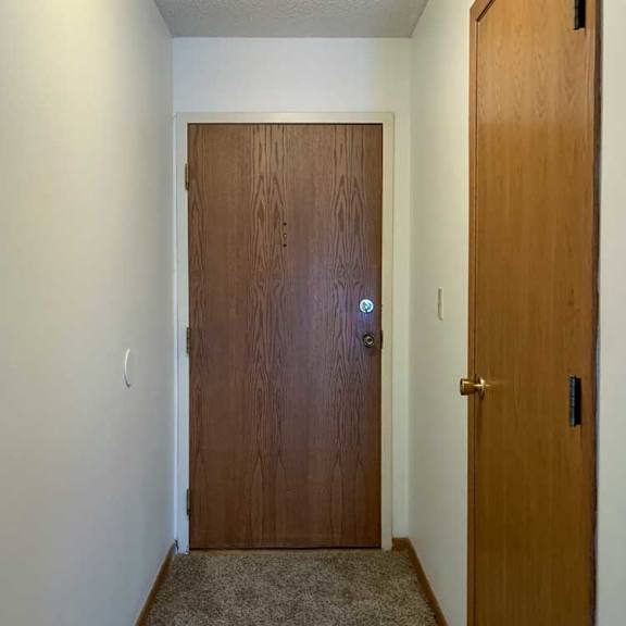 Thumbnail 2 of 30 a hallway with a brown door and a carpeted floor