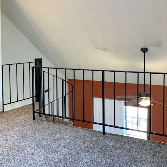 Thumbnail 21 of 30 a loft area with a carpeted floor and a view of the living room below