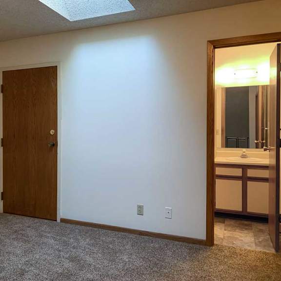 Thumbnail 30 of 30 a loft area with a skylight and a door to a bathroom