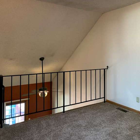 Thumbnail 22 of 30 a loft area with a skylight and a metal railing