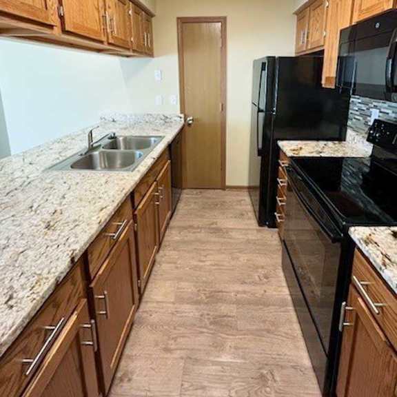 Thumbnail 2 of 17 a kitchen with black appliances and wooden cabinets
