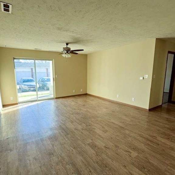 Thumbnail 6 of 17 a living room with hardwood flooring and a ceiling fan