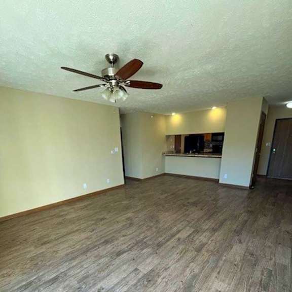 Thumbnail 7 of 17 a living room with a ceiling fan and wooden flooring
