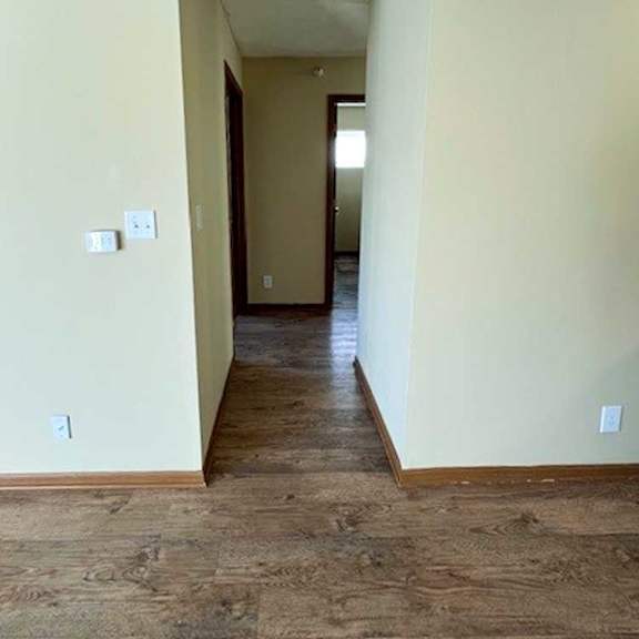 Thumbnail 9 of 17 a hallway with wood flooring and white walls