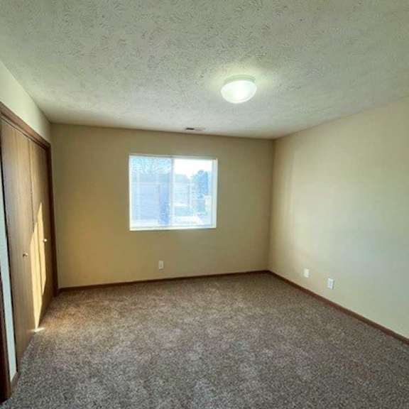 Thumbnail 11 of 17 a bedroom with a carpeted floor and a window