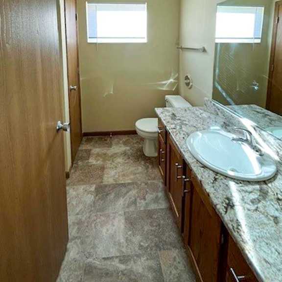 Thumbnail 14 of 17 a bathroom with a vanity sink, a mirror, a linen closet, and a window