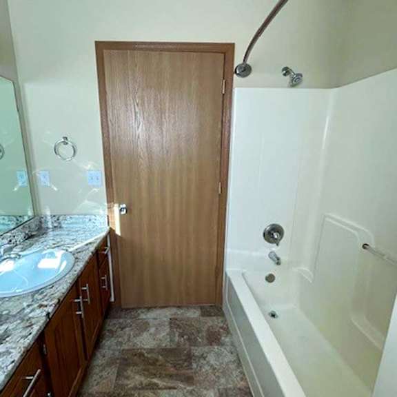 Thumbnail 16 of 17 a bathroom with a tub shower, sink, and mirror