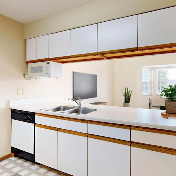 Thumbnail 9 of 40 A kitchen with a white counter, white cabinets, and a pass through to the living room.