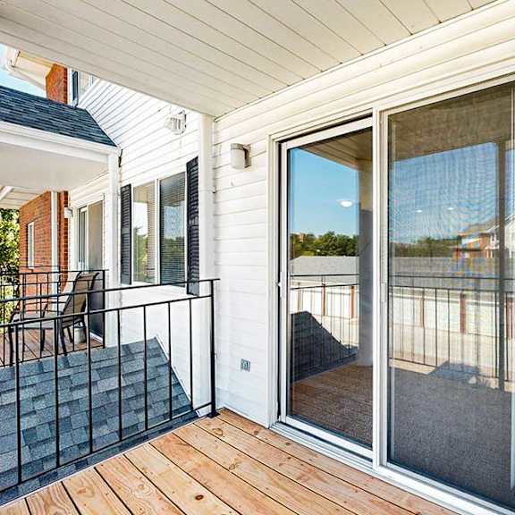 Thumbnail 17 of 33 A balcony with a sliding glass door, and a metal railing.