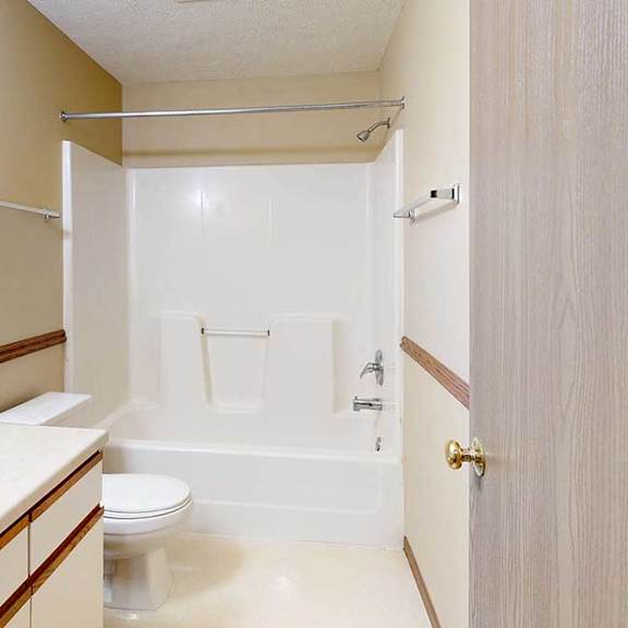 Thumbnail 29 of 33 A bathroom with a vanity sink, large mirror, towel rack, and tub shower.