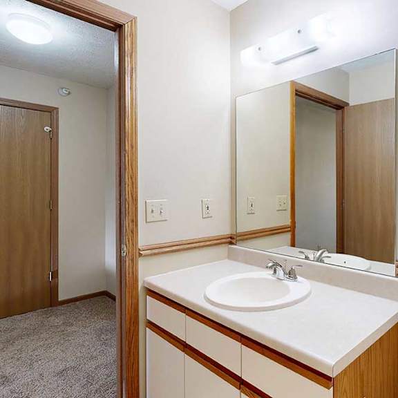 Thumbnail 28 of 33 A bathroom with a vanity sink, mirror, towel rack, and overhead lighting.