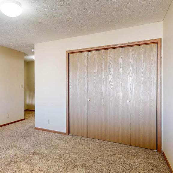 Thumbnail 24 of 33 A loft bedroom with a carpeted floor and double-door closet.