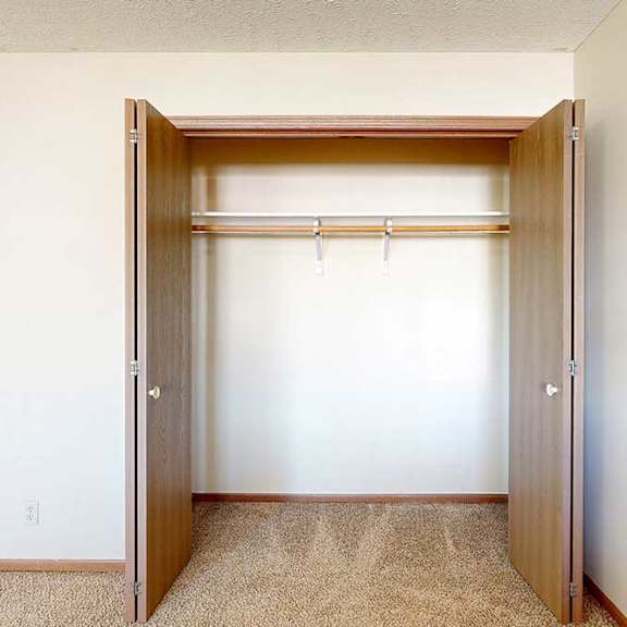 Thumbnail 25 of 33 A loft bedroom with an open double-door closet.
