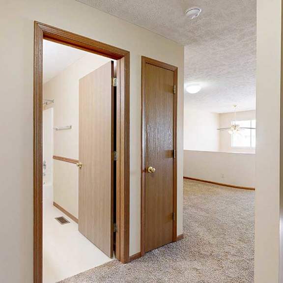Thumbnail 27 of 33 A hallway at the top of the stairs with a door to the loft bathroom and a linen closet.