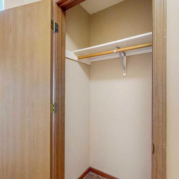 Thumbnail 10 of 33 A coat closet with a built-in shelf and hanging rod.