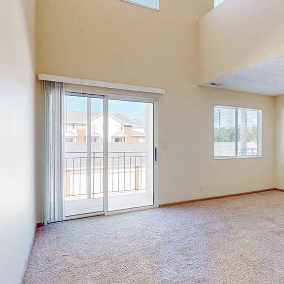 Thumbnail 14 of 33 A spacious living room with a sliding glass door and a window.