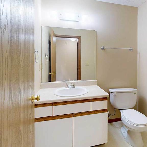 Thumbnail 4 of 33 A bathroom with a vanity sink, mirror, and towel rack.