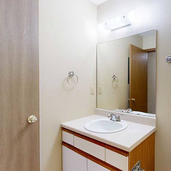 Thumbnail 5 of 33 A bathroom with a vanity sink, mirror, and towel rack.