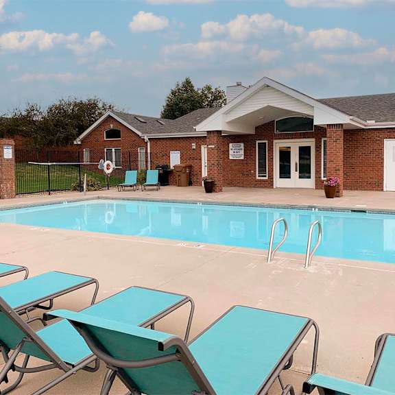 a pool with loungers in front of a building.