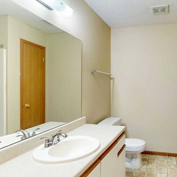 Thumbnail 19 of 21 A bathroom with white and oak cabinetry, a wide vanity sink, and a large mirror with overhead lighting.