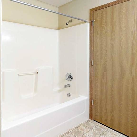 Thumbnail 20 of 21 A bathroom with a white tub shower and chrome finishes.