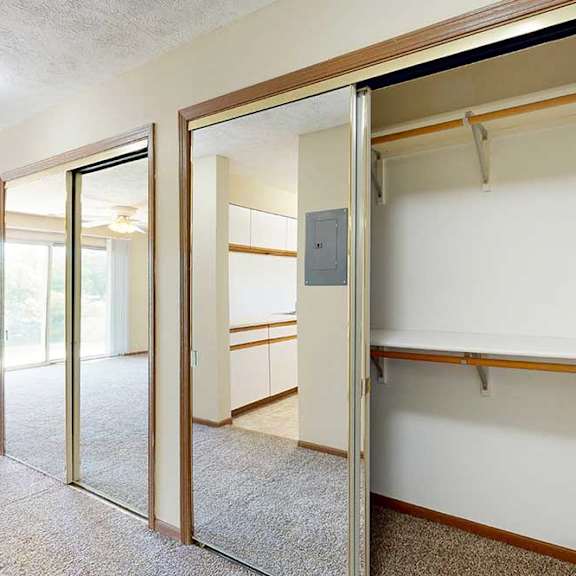 Thumbnail 3 of 21 A hall closet with sliding mirror doors, and built-in shelves and hanging space.