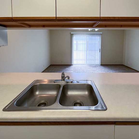 Thumbnail 4 of 13 a kitchen with a double sink and a window to the living room