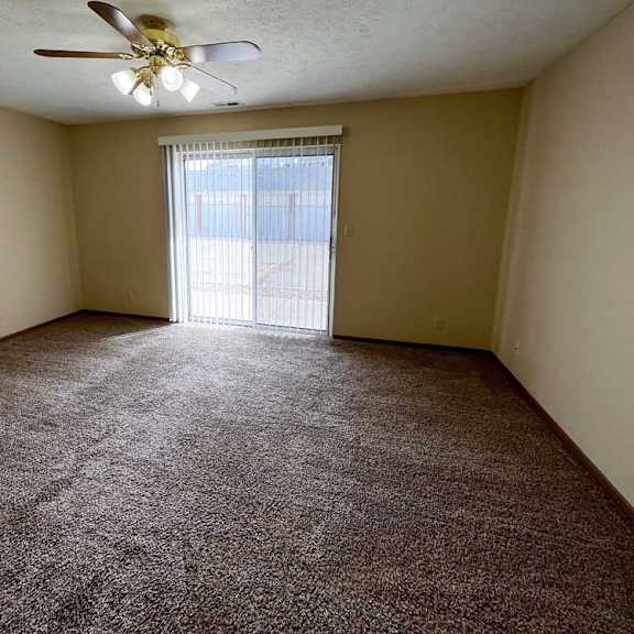 Thumbnail 7 of 13 a living room and sleeping area with a ceiling fan and carpeted floor