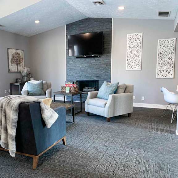 a clubhouse community room with a couch and a tv