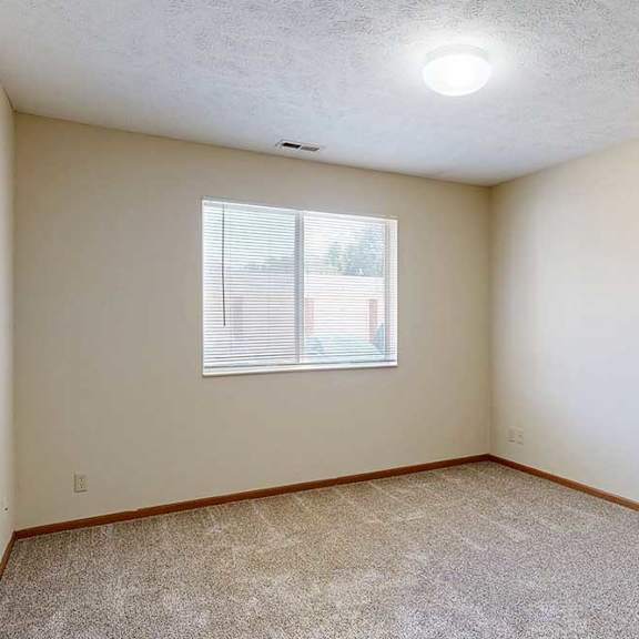 Thumbnail 24 of 29 A bedroom with a window and carpeted floor.