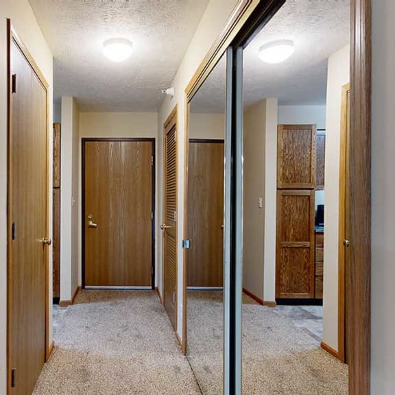 Thumbnail 3 of 20 an entry hallway with a mirrored closet and a coat closet