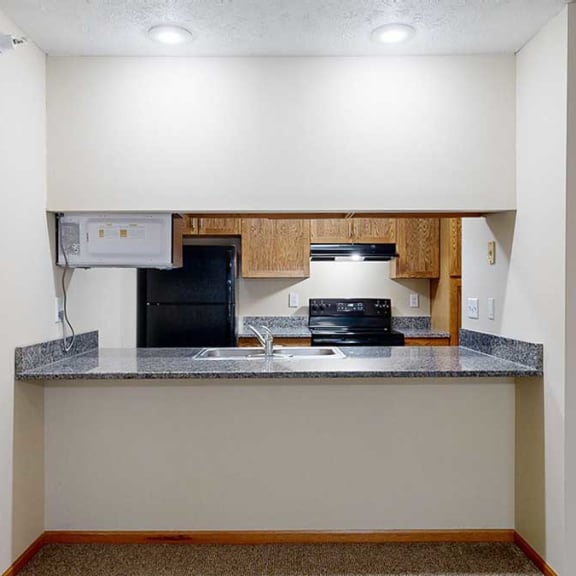 Thumbnail 8 of 20 a kitchen with a granite countertop that opens up to the living room