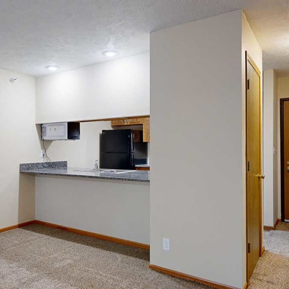 Thumbnail 9 of 20 a living area with a breakfast bar overlooking the kitchen, creating an open layout