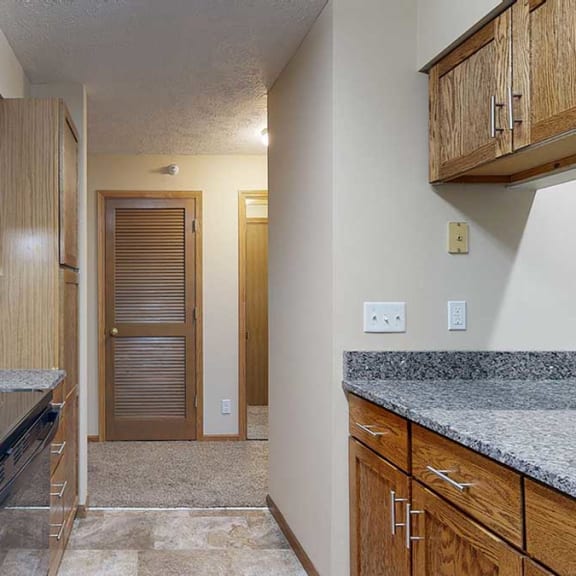 Thumbnail 4 of 20 a galley kitchen with granite countertops and wooden cabinets