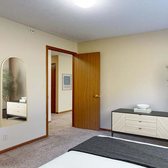Thumbnail 10 of 29 A bedroom with a bed, dresser, and mirror.