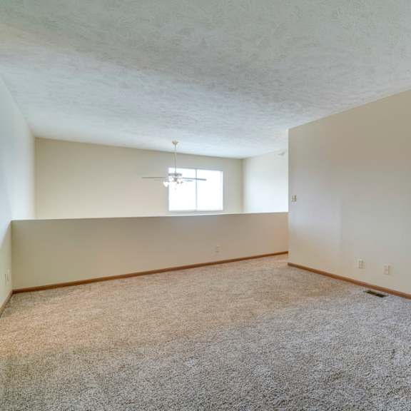 Thumbnail 13 of 15 A room with a carpeted floor and a window.