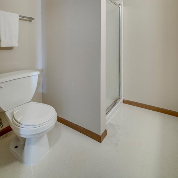 Thumbnail 15 of 15 A white toilet with a towel hanging on the wall.