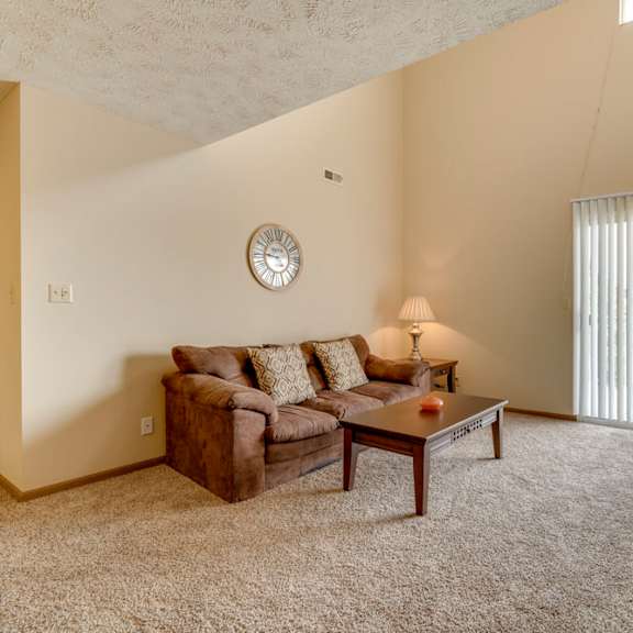 Thumbnail 2 of 15 a living room with a couch coffee table and a window