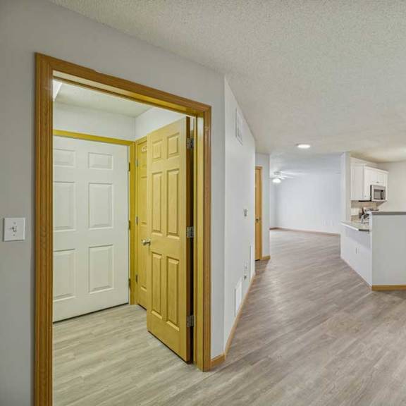 Thumbnail 16 of 29 A room with a wooden floor and a white wall with a door.