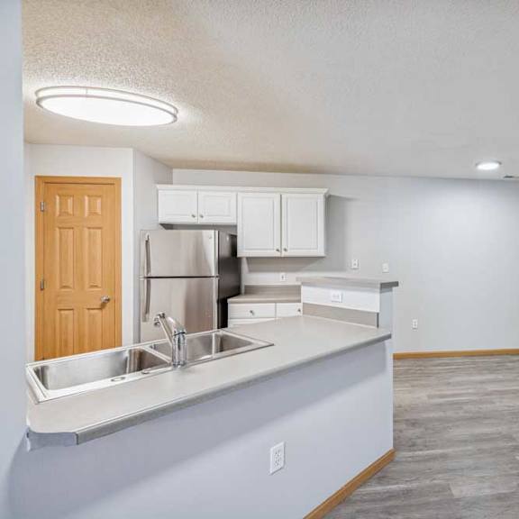 Thumbnail 18 of 29 A kitchen with a refrigerator, sink, and cabinets.