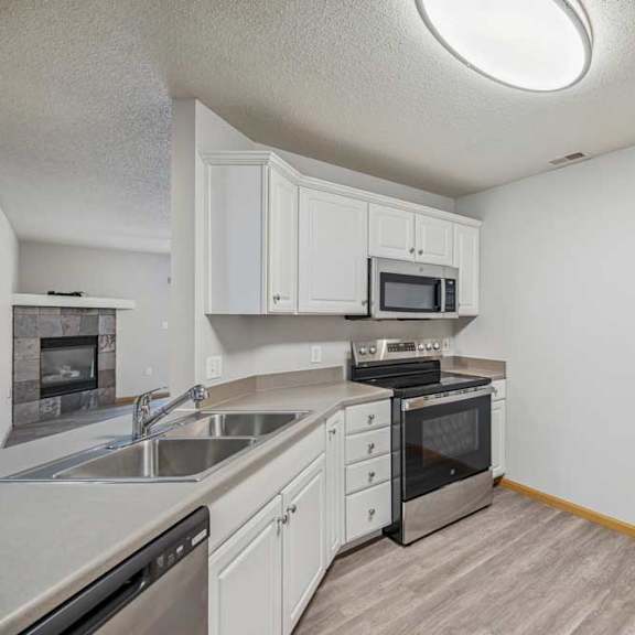 Thumbnail 27 of 29 A kitchen with white cabinets and a black oven.