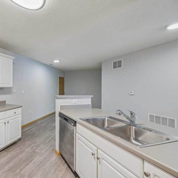 Thumbnail 25 of 29 A kitchen with a refrigerator, sink, and cabinets.