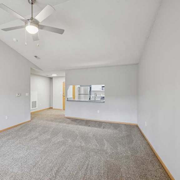 Thumbnail 11 of 13 A room with a ceiling fan and carpeted floor.